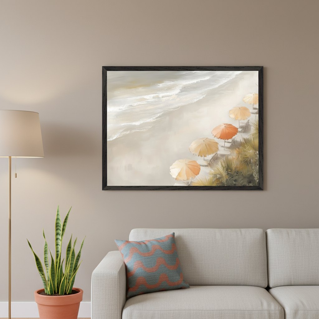 Living room with a light gray sofa and patterned cushion. A framed painting of an aerial beach view with white waves and orange beach umbrellas hangs above the right side of the sofa. A floor lamp and snake plant are on the left.