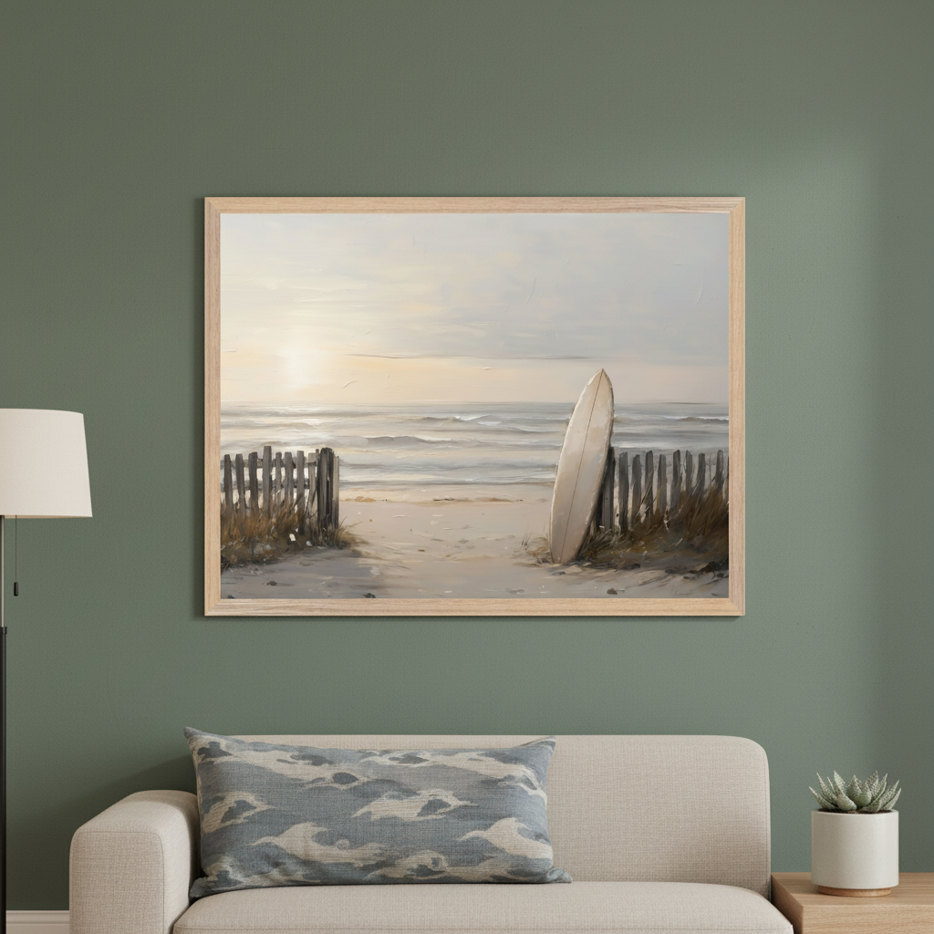 Living room with a beige sofa against a green wall. A large framed painting hangs above the sofa, depicting a sandy beach path through dunes, wooden fences, and a surfboard near the ocean at sunset.