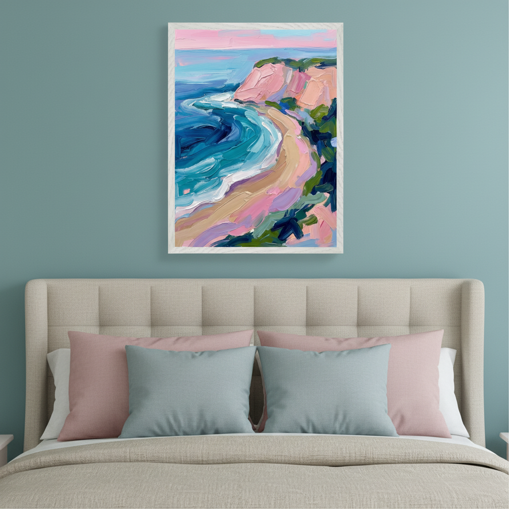 Modern bedroom with a beige upholstered bed and pink and blue pillows. A framed impressionistic painting of a colorful beach with pink cliffs and turquoise water hangs above the bed.