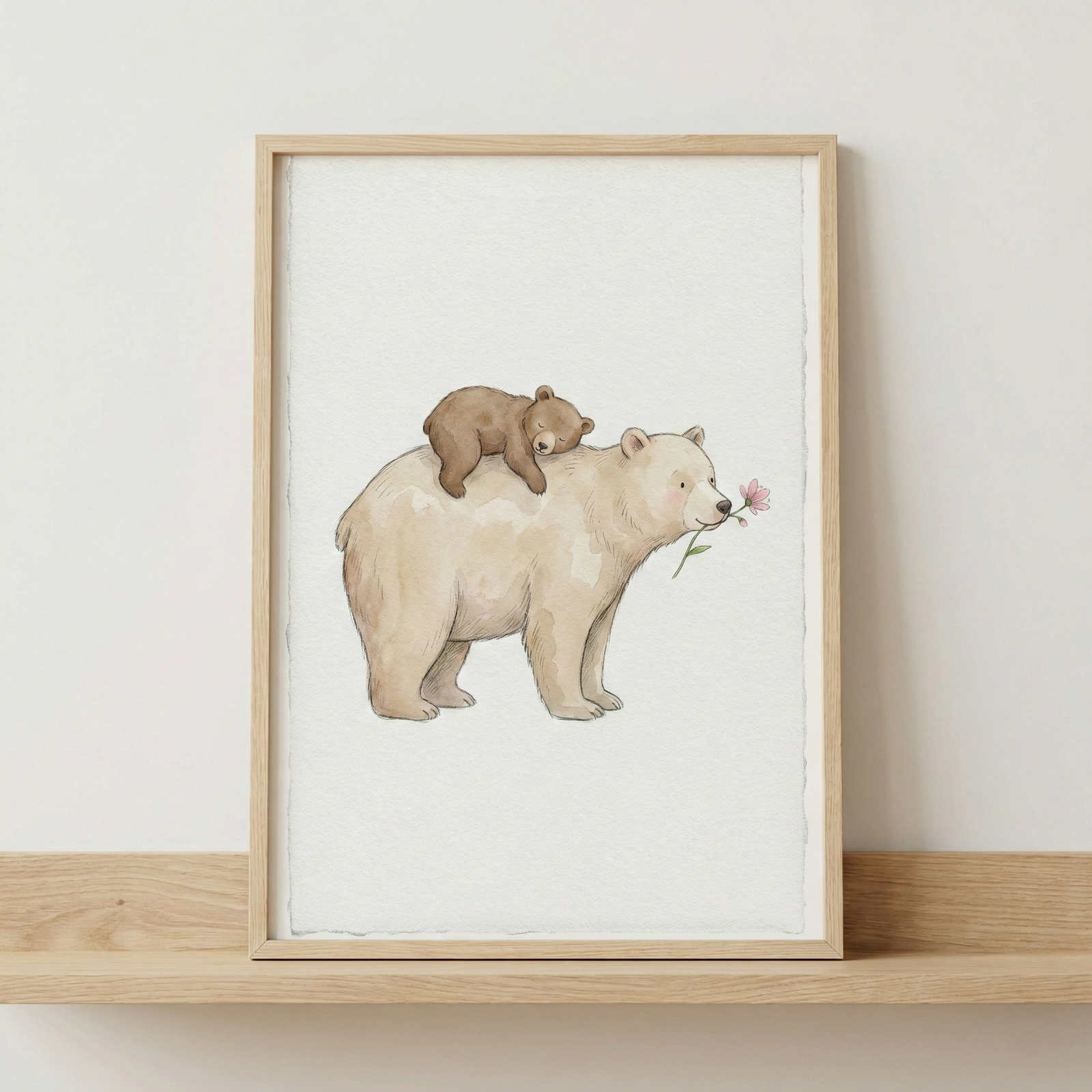 A framed watercolor-style illustration is displayed on a light wooden shelf against a plain white wall. The artwork depicts a large, cream-colored bear standing in profile, holding a single pink flower in its mouth. Resting peacefully on its back is a smaller, brown bear cub curled up in sleep. The illustration has a gentle, storybook feel with soft textures on a white background. The piece is encased in a simple, light-toned wooden frame.