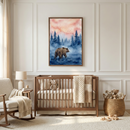 A cozy, neutrally-toned nursery features a framed watercolor-style artwork of a brown bear walking through a misty forest of pine trees under a pink sky. Below the art is a wooden crib with a cream-colored blanket. To the left sits a wooden rocking chair with a soft throw and a side table holding a simple lamp. A woven basket filled with stuffed animals and several wooden toys rest on a plush, light-colored rug, creating a warm and inviting atmosphere.