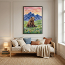 A framed vertical watercolor illustration of a brown bear sitting in a meadow of wildflowers. Behind the bear are blue mountains and a pink and orange sunset sky. The art is centered on a beige wall above a wooden daybed. The daybed is styled with pillows in shades of white, blue, and rust, and a chunky knit throw. To the left, a small lamp glows on a stack of books. A woven rug is on the floor, and a window to the right lets in natural light.