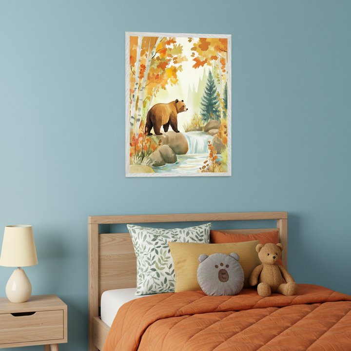 Children's bedroom with a light blue wall. A wooden bed with orange bedding and pillows sits below a large framed watercolor painting. The artwork depicts a brown bear on rocks next to a waterfall in an autumn forest. A wooden nightstand with a lamp is to the left of the bed.