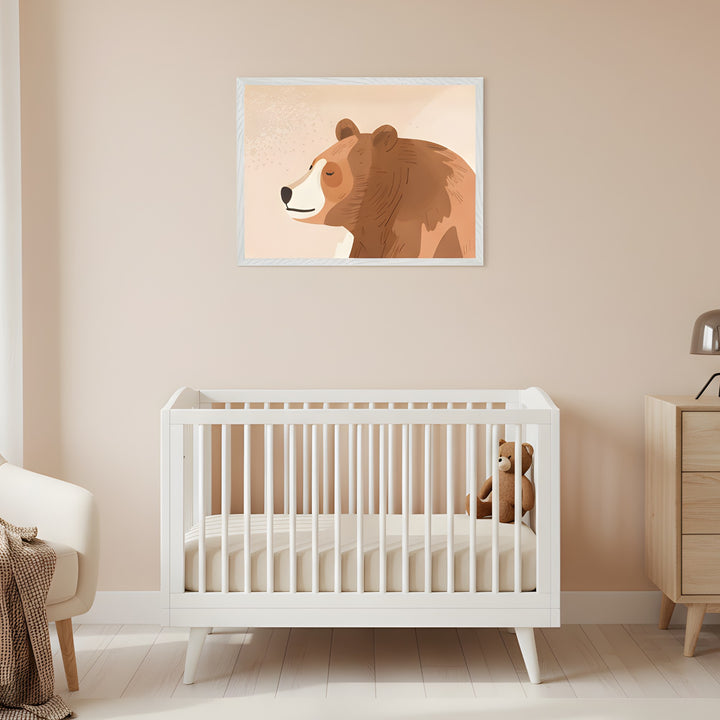 Modern nursery with a white crib. A framed illustration of a sleeping brown bear hangs above the crib on a light beige wall. A cream armchair is to the left, and a wooden dresser to the right.