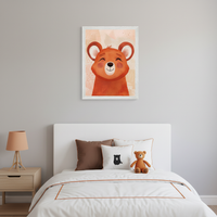 Kid's bedroom with a white bed, brown pillows, and a wood nightstand with a lamp. A framed illustration of a happy, smiling cartoon bear in warm orange and peach tones hangs on the gray wall above the bed.