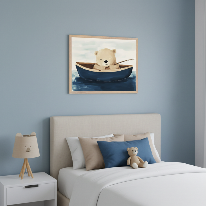 Kid's bedroom with a neutral upholstered bed and white nightstand. A framed watercolor-style painting of a sleepy brown bear in a blue boat, holding a fishing rod on the water, hangs above the bed. A teddy bear sits on the bed, and a bear-shaped lamp is on the nightstand.