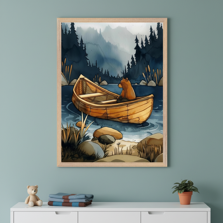 Framed illustration of a bear sitting calmly in a wooden rowboat on a serene lake, surrounded by reeds, rocks, and dense pine forest with misty mountains in the background. The artwork hangs above a white cabinet topped with a teddy bear, folded blankets, and a small potted plant, creating a cozy woodland-themed scene.