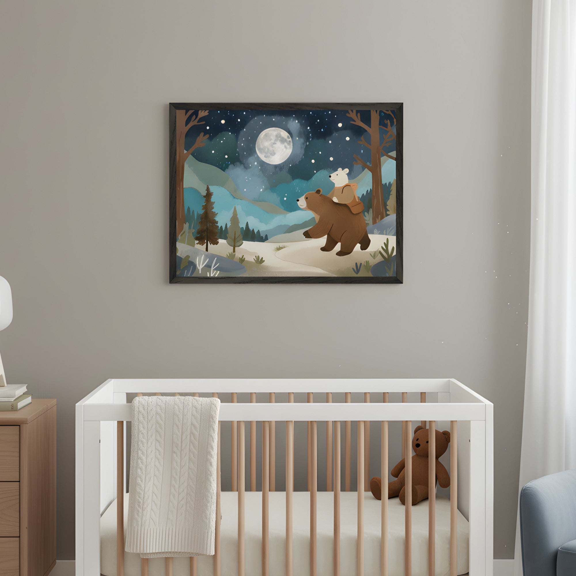 Modern nursery with a white crib and light wood dresser. A framed watercolor illustration of a brown bear carrying a white bear through a forest under a full moon and starry sky hangs above the crib. A light blue armchair is partly visible.