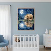Modern nursery with a white crib and blue armchair. A framed watercolor painting of a mama bear and two cubs by a moonlit lake, with their reflection, hangs on a light blue wall above the crib. A white dresser is on the right.