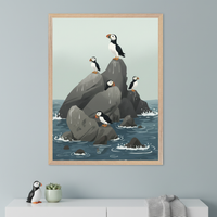 Modern room with a white dresser. A large framed print of cartoonish puffins on dark rocks in a blue ocean hangs above the dresser. A puffin figurine, a succulent, and a folded blanket are on the dresser.