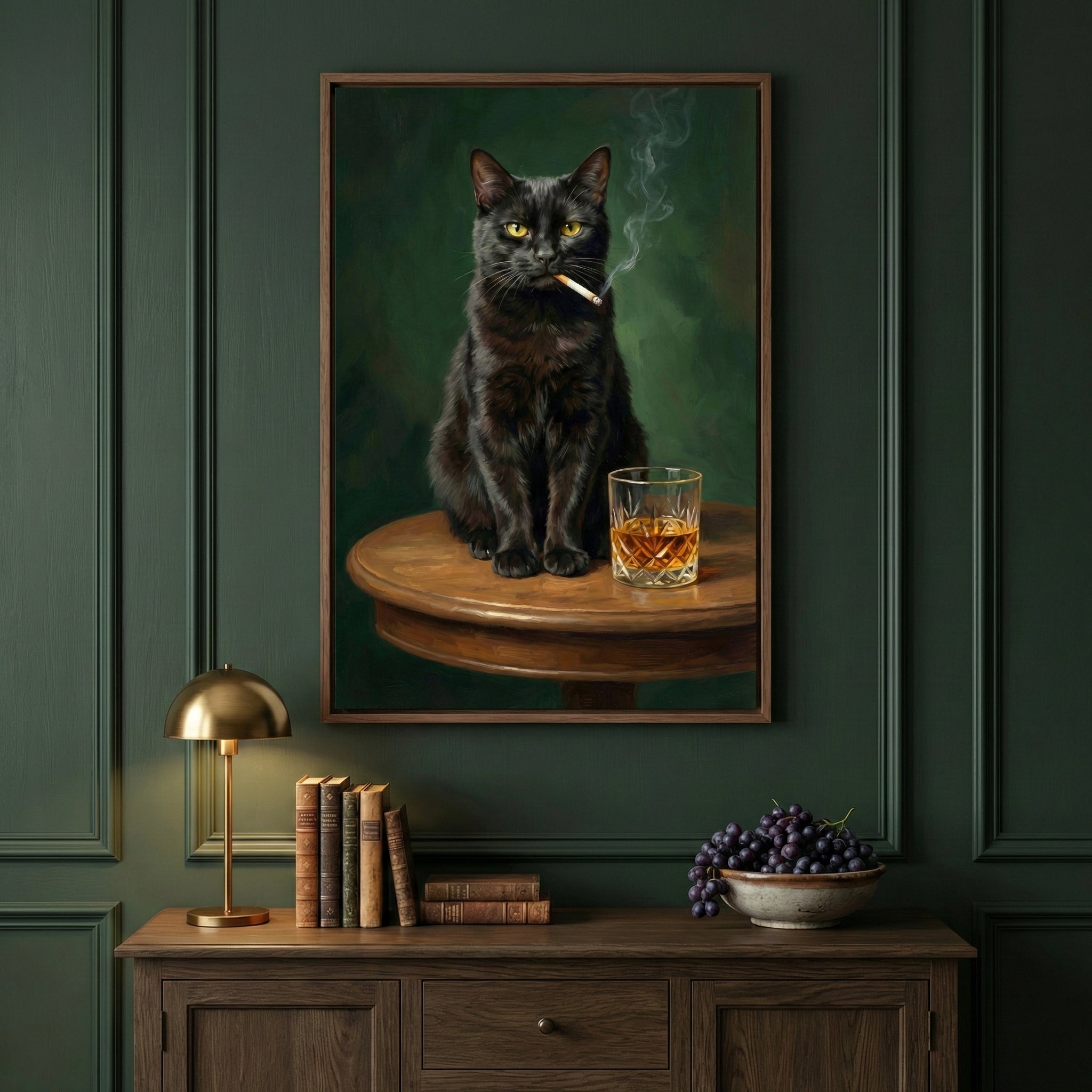 A framed portrait on a dark green wood-paneled wall depicts a black cat with yellow eyes sitting on a small wooden table. The cat holds a lit cigarette in its mouth as smoke curls upward, and a glass of amber liquid sits beside it. Below the artwork, a dark wood cabinet is decorated with a small brass lamp, a row of antique books, and a bowl of purple grapes.