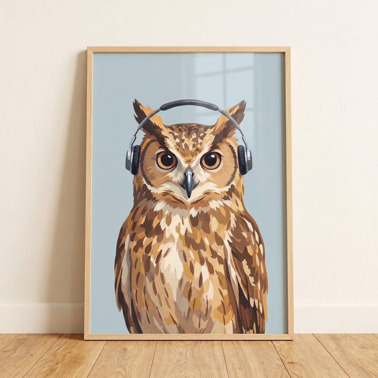 Framed black headphone listening owl wall art leaning against a white wall on a wooden floor.