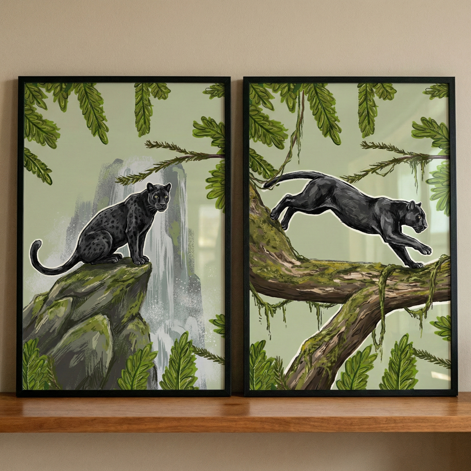 Two thin black frames sit side-by-side on a light-colored wooden shelf against a neutral wall. Each frame contains a jungle-themed illustration on a muted sage-green background. The left illustration features a black leopard sitting on a mossy rock cliff with a tall waterfall behind it. The right illustration shows a similar black leopard walking across a thick, mossy tree branch. Both scenes are framed by stylized green tropical leaves and branches.