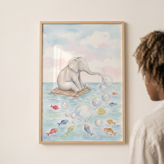 Framed blowing bubbles baby elephant wall art depicts an elephant on a raft at sea with bubbles and colorful fish.