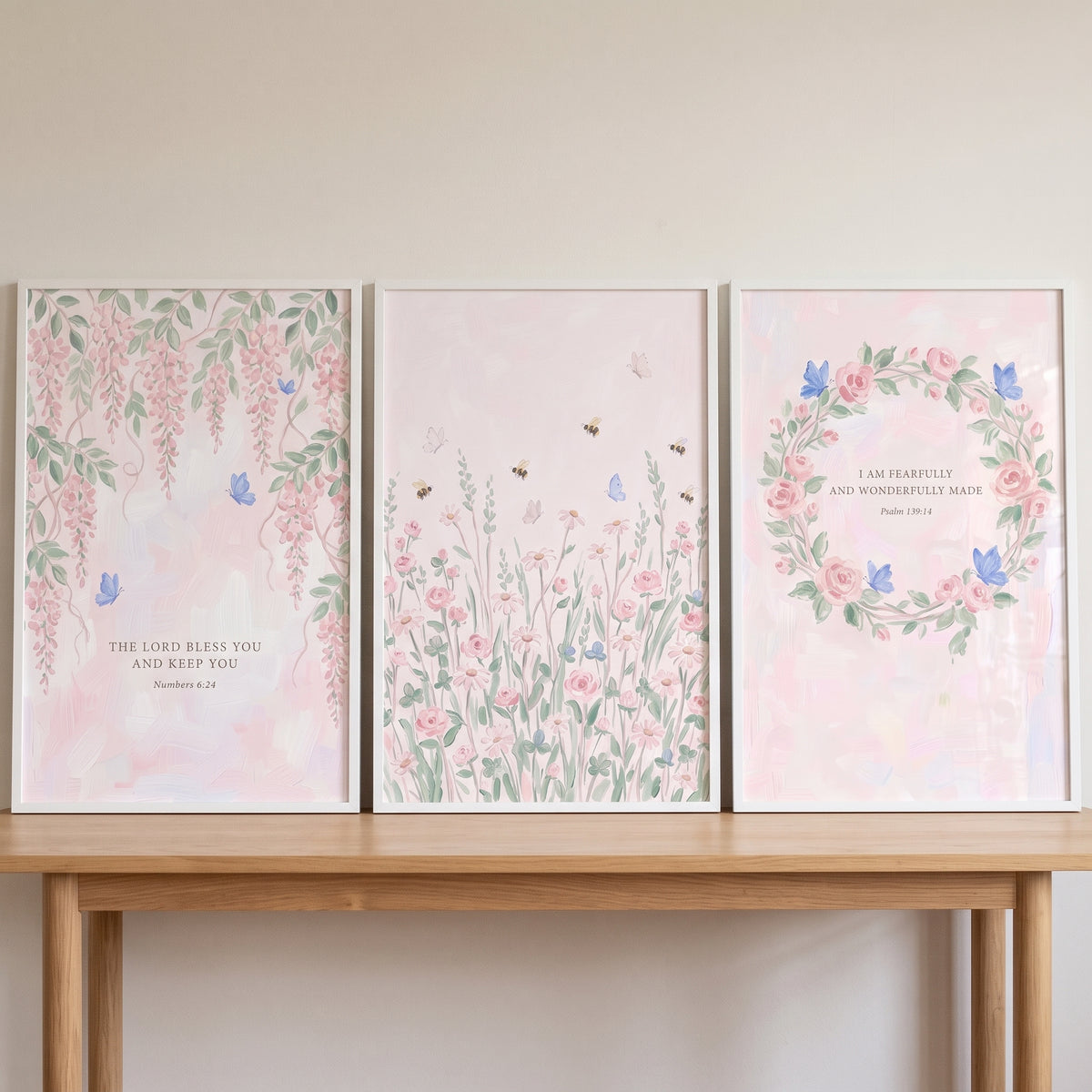 Blue butterfly pink garden wall art set of 3 featuring floral designs and bible verses on a wooden table.
