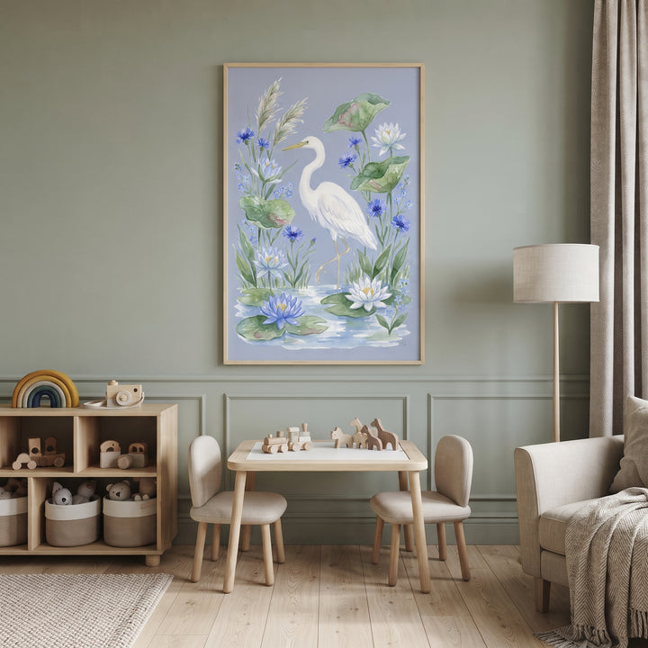 Blue cornflower white egret bird wall art hangs in a sage green playroom above a small wooden table and chairs.