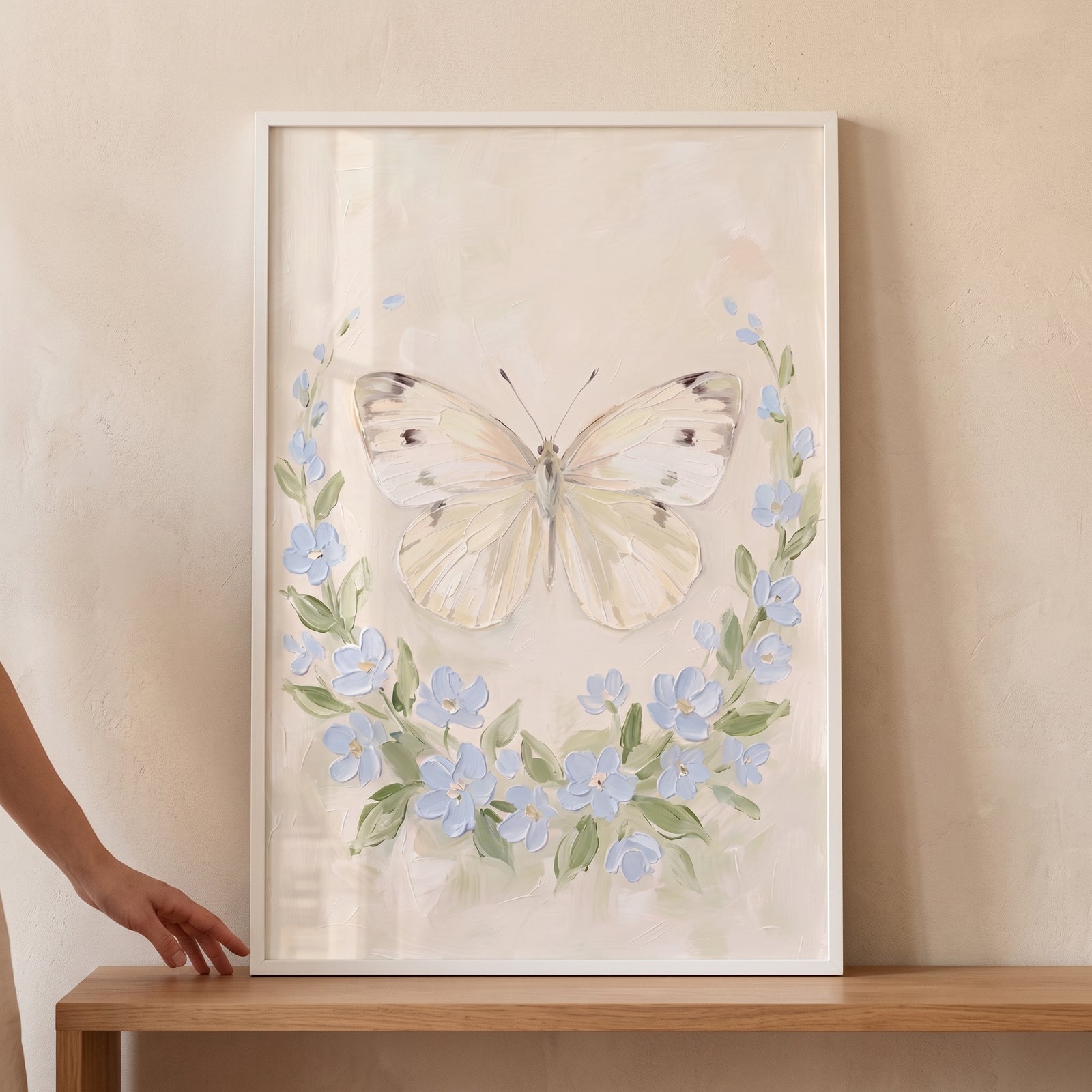 Textured blue floral wreath butterfly wall art in a white frame, with a spotted cream butterfly and pale blue blossoms.