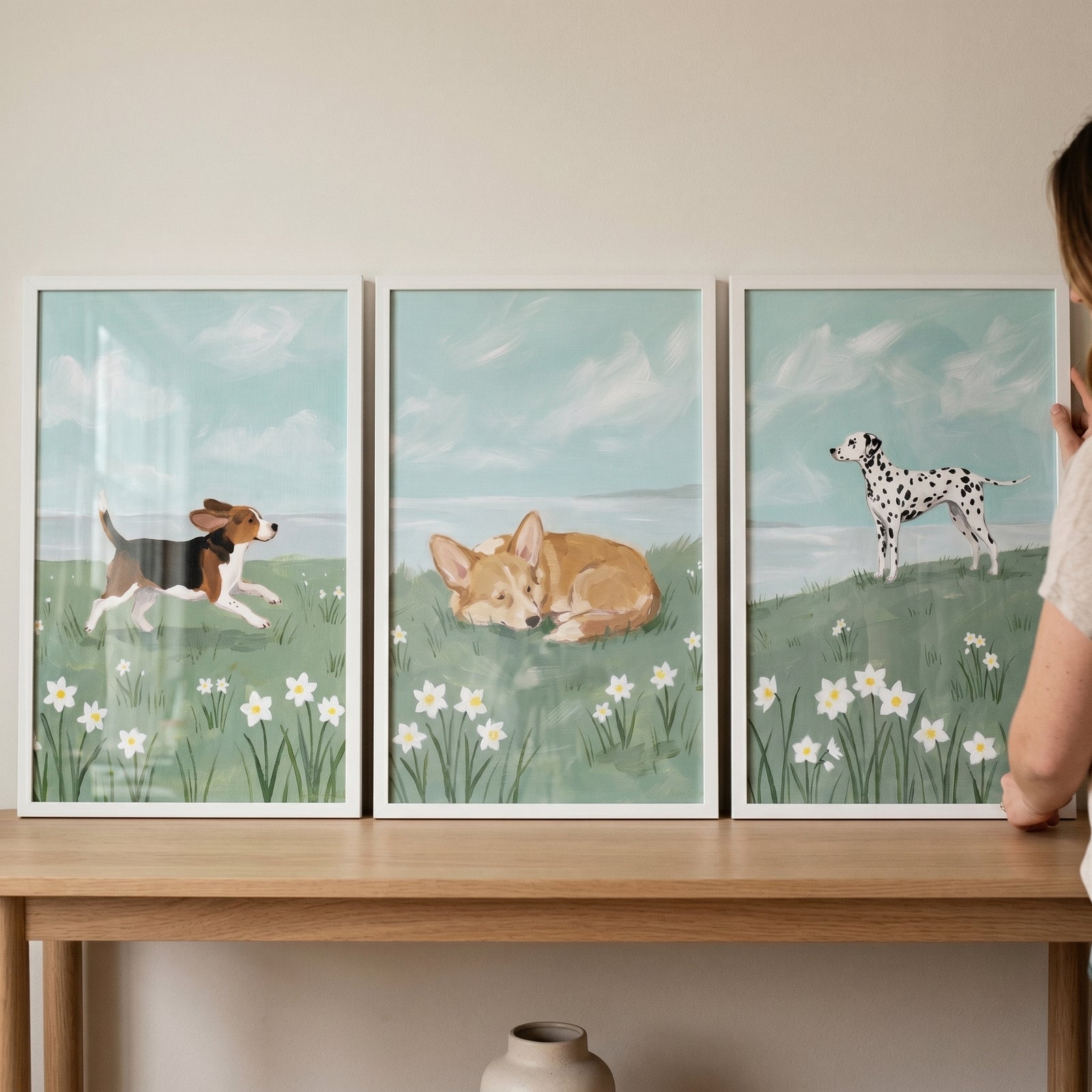 Beagle, corgi, and dalmatian prints in this blue sky coastal dogs wall art set of 3 with white flowers.