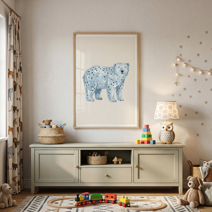 Blue spotted polar bear wall art above a cabinet in a kids room with an owl lamp, wooden train, and star wall decals.