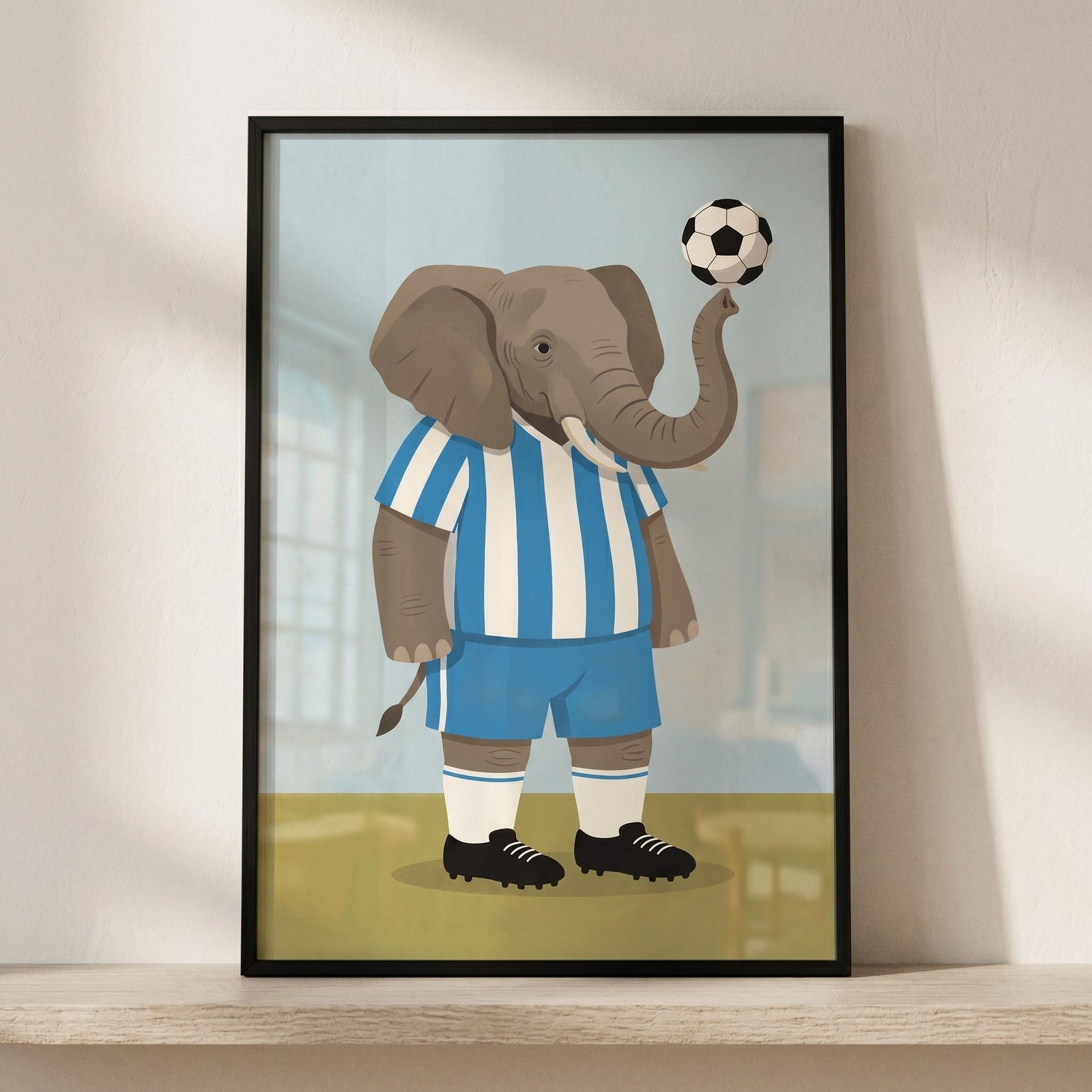Framed blue striped jersey elephant wall art shows a cartoon elephant in soccer gear balancing a ball on its trunk.