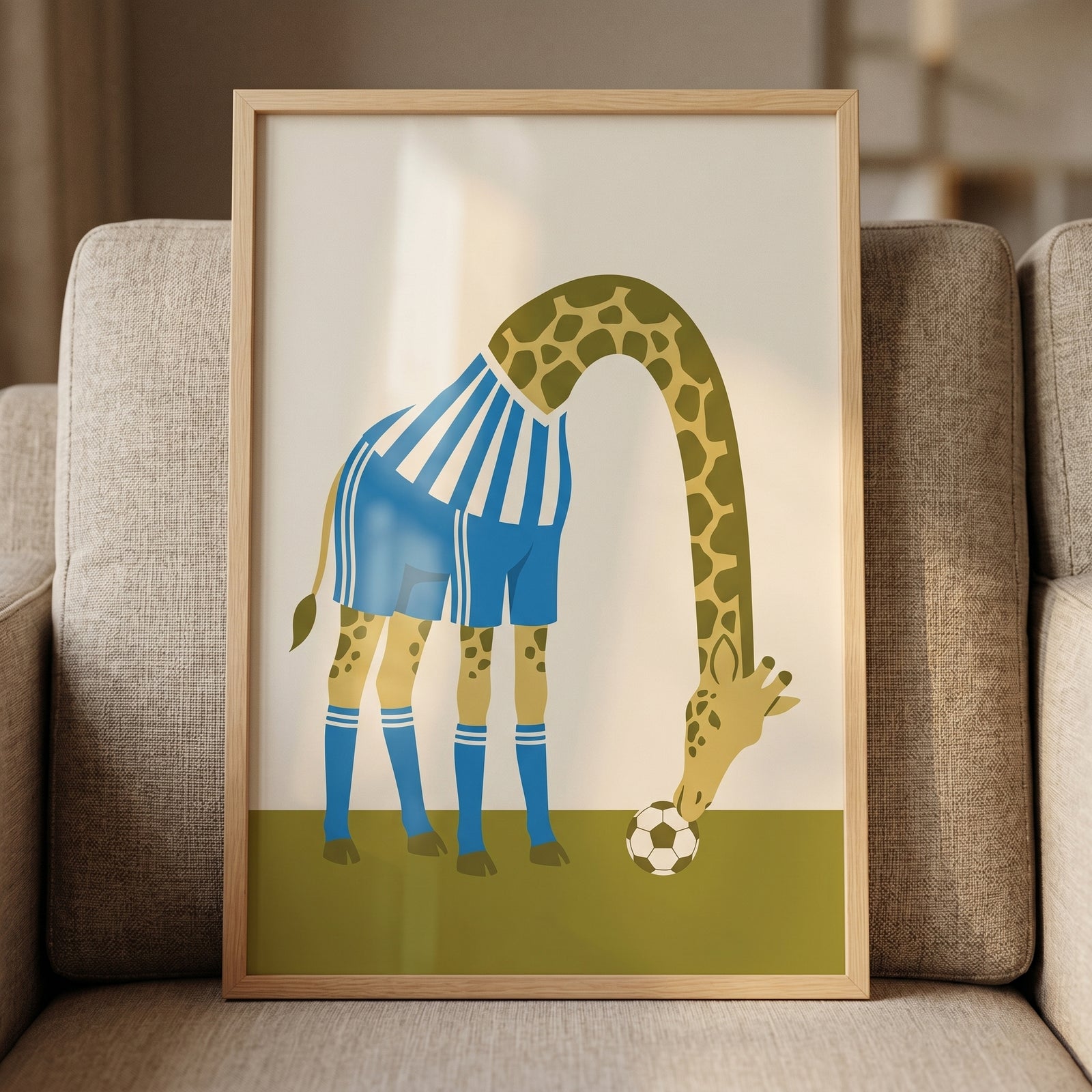 Framed blue striped jersey giraffe wall art shows a giraffe in a soccer uniform bending its long neck to a soccer ball.