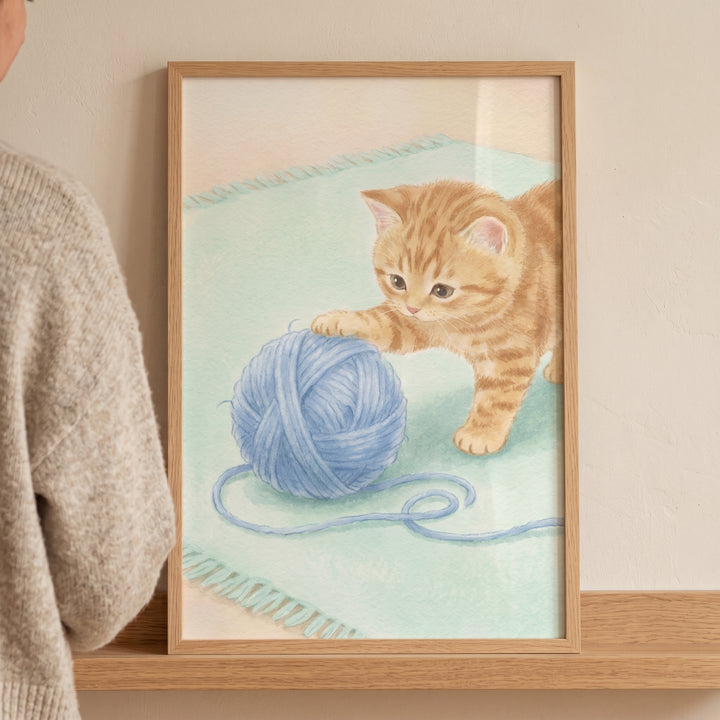 Orange tabby kitten playing with a blue ball of yarn on a light green rug in this blue yarn ball kitten artwork.