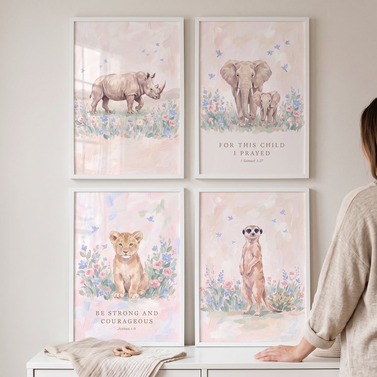 Blush blossom safari animals wall art set of 4 featuring a rhino, elephants, lion cub, and meerkat in white frames.