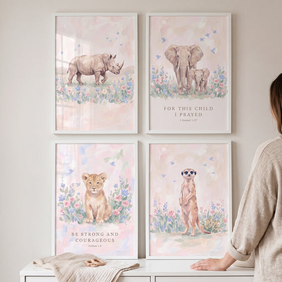Blush blossom safari animals wall art set of 4 featuring a rhino, elephants, lion cub, and meerkat in white frames.