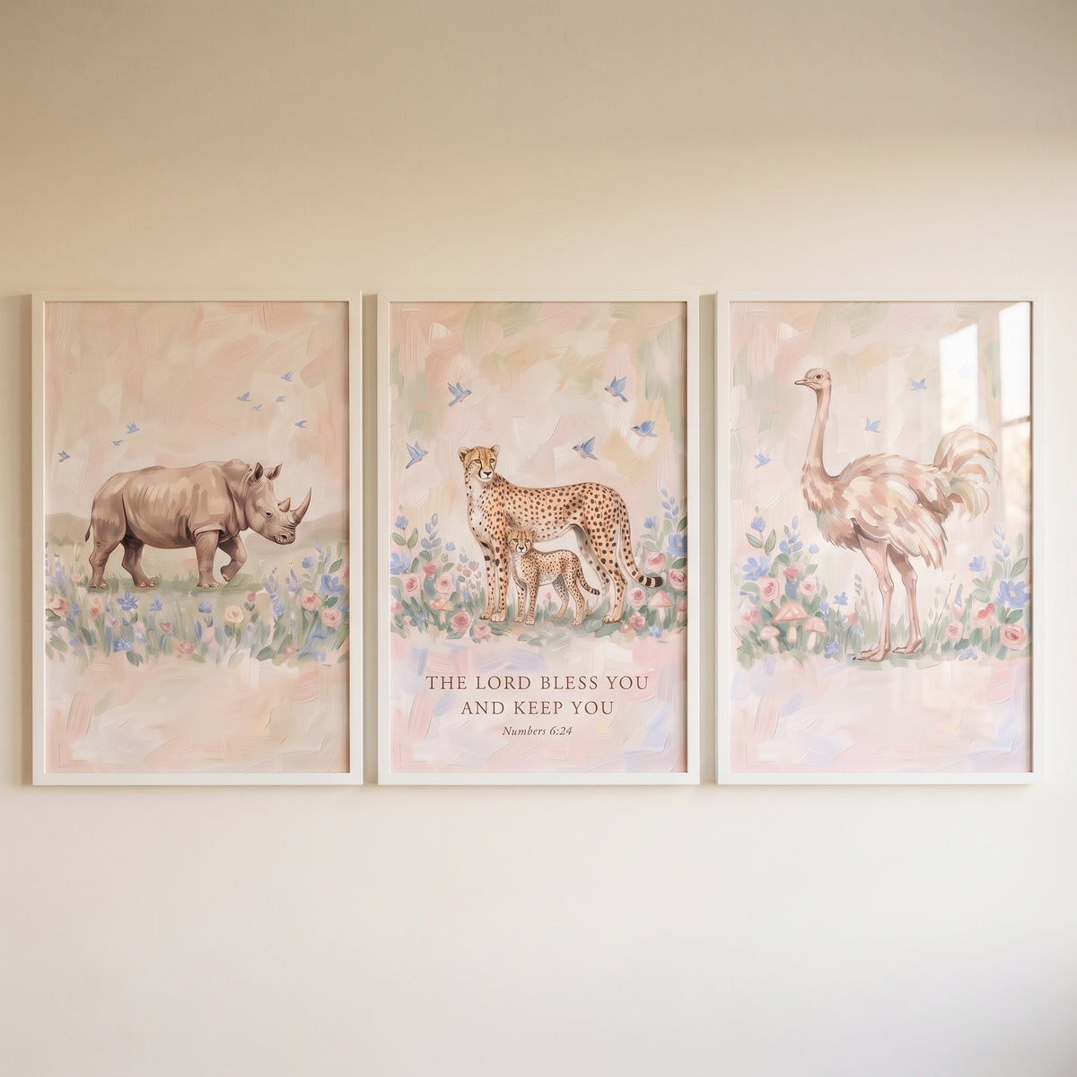 Blush bluebird safari animals wall art set of 3 depicts a rhino, cheetahs, and ostrich in soft floral scenes on a shelf.