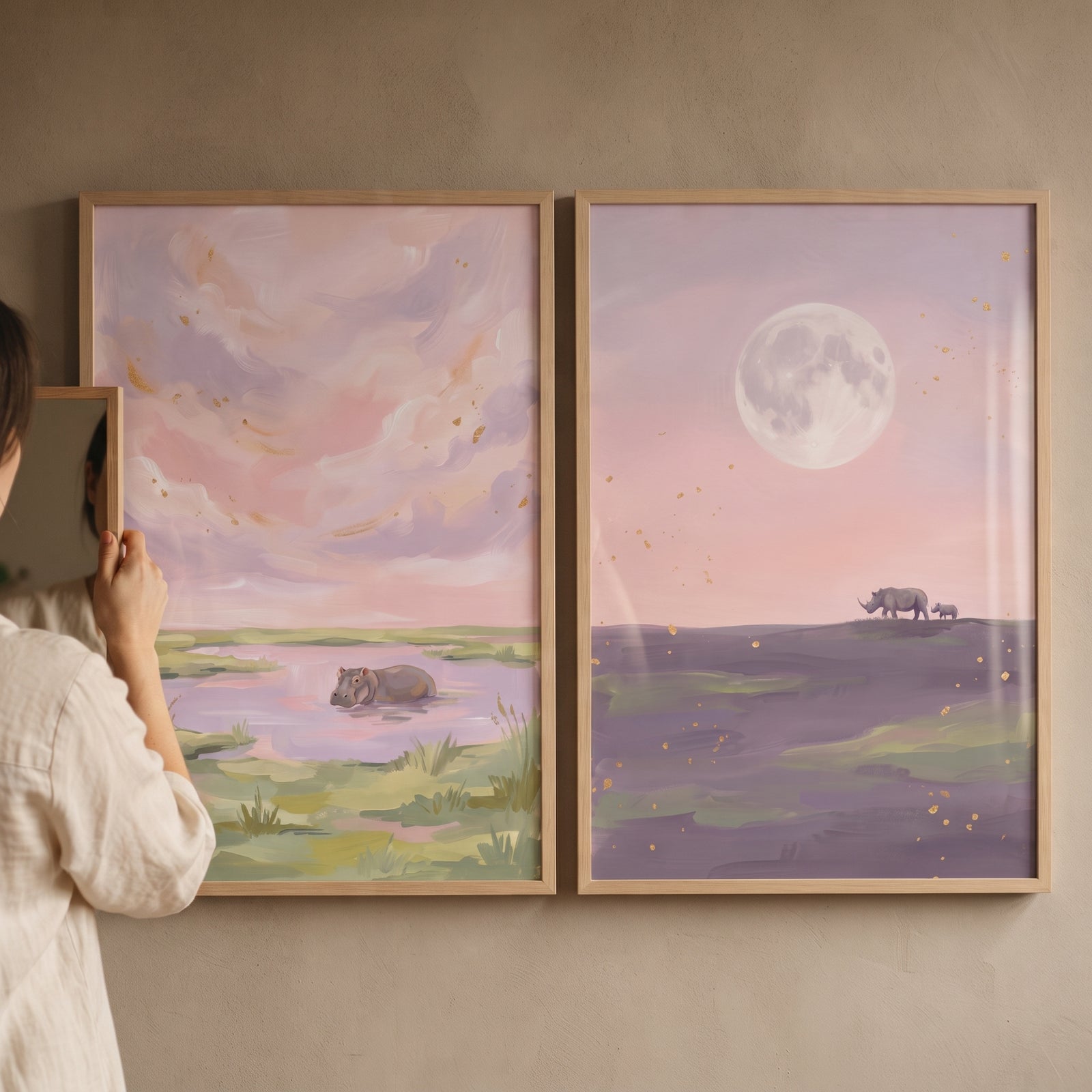 Blush lavender safari animals wall art set of 2 featuring a hippo in a pool and rhinos under a moon with pink clouds.