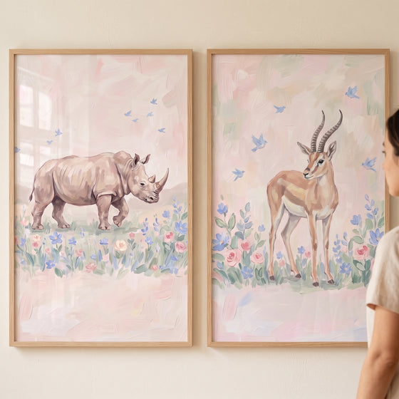 Blush meadow safari animals wall art set of 2 featuring a rhino and gazelle in soft floral fields with wood frames.