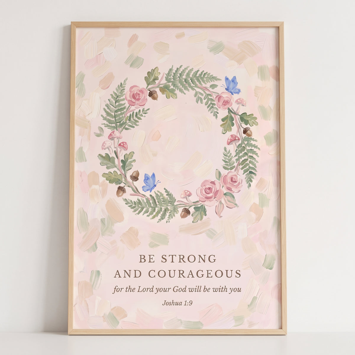 Blush pink botanical wreath bible artwork featuring Joshua 1:9 surrounded by roses, ferns, and blue butterflies.