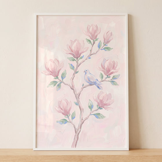 Blush pink magnolia floral wall art features a small blue bird perched on a branch with pink blossoms.