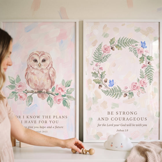 Blush pink scripture quote bible wall art set of 2 featuring an owl, floral wreath, and verses above a nursery shelf.