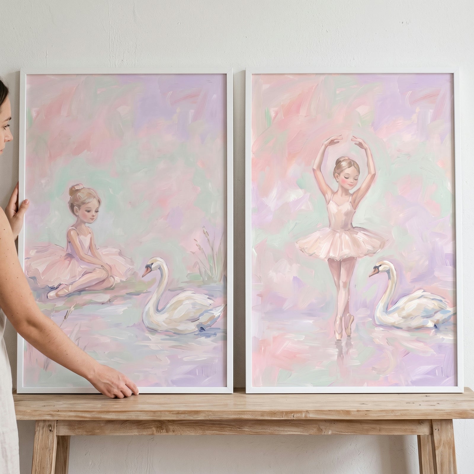 Blush pink swan ballet wall art set of 2 featuring a ballerina and a swan in soft pastel colors on a wooden bench.