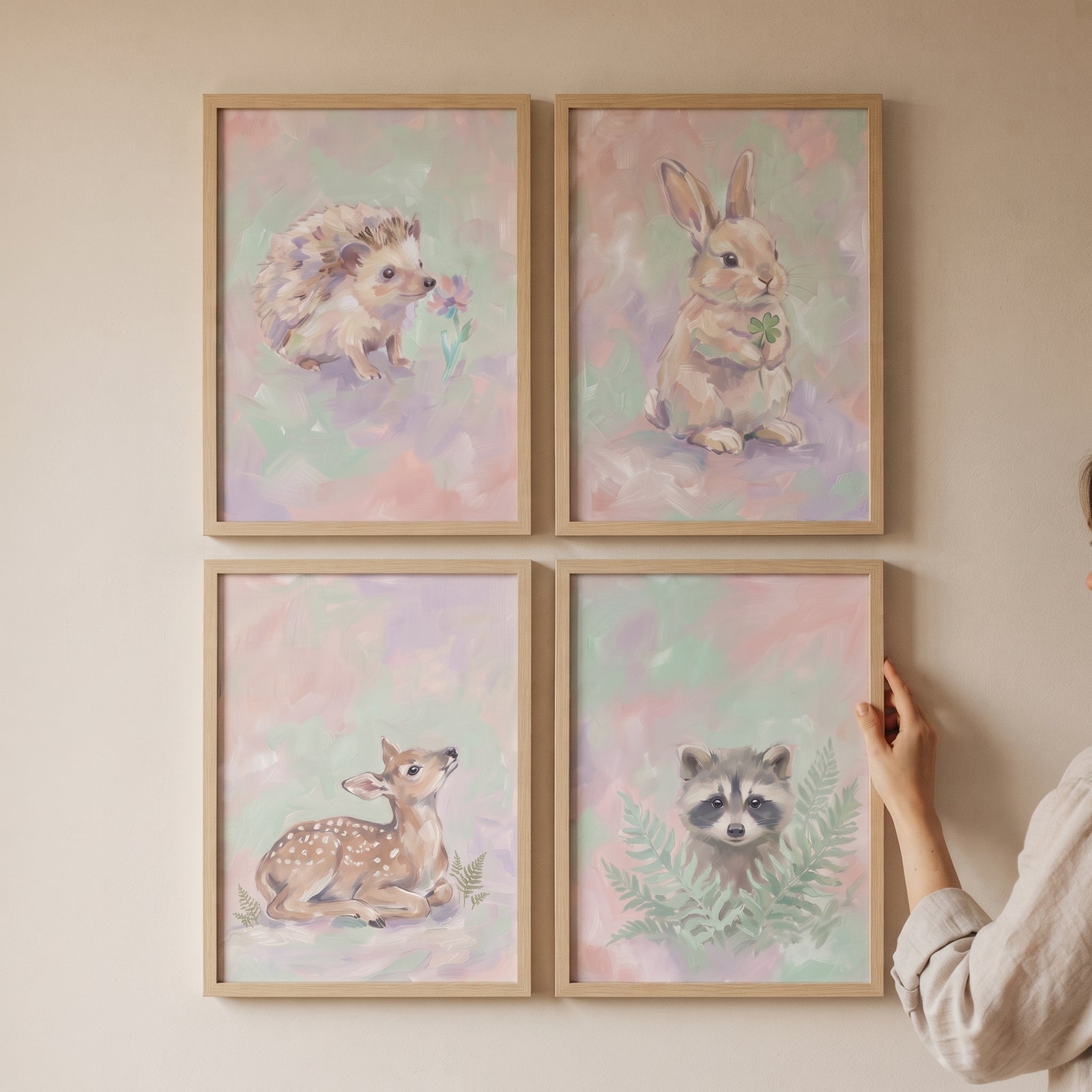 Blush rose woodland animal wall art set of 4 with a hedgehog, rabbit, fawn, and raccoon in light wood frames.