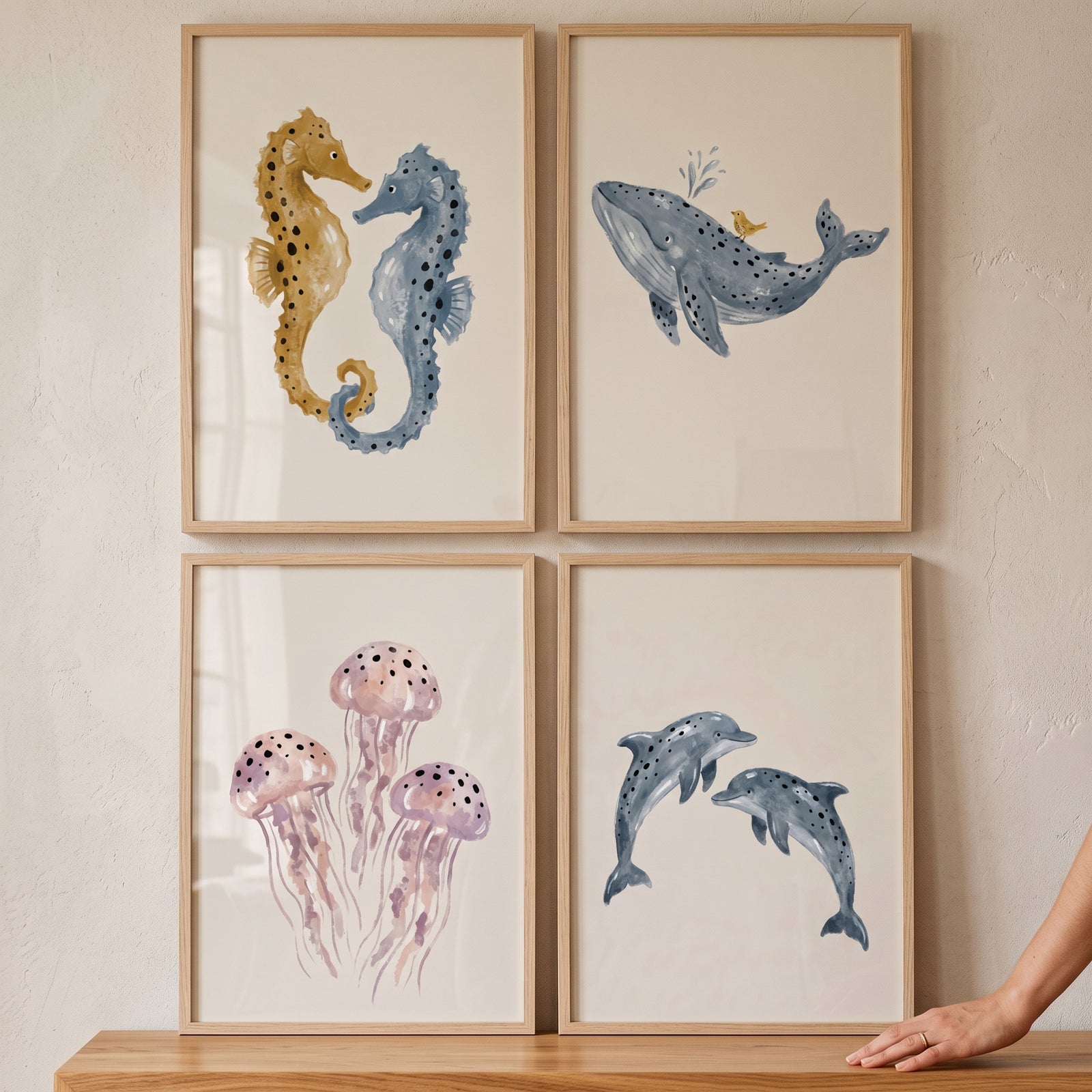 Boho watercolor sea animal wall art set of 4 featuring seahorses, a whale, jellyfish, and dolphins in light wood frames.