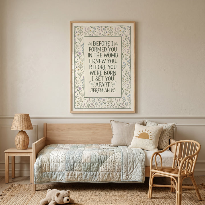 Botanical border bible verse wall art with Jeremiah 1:5 hangs in a neutral nursery above a daybed and rattan chair.
