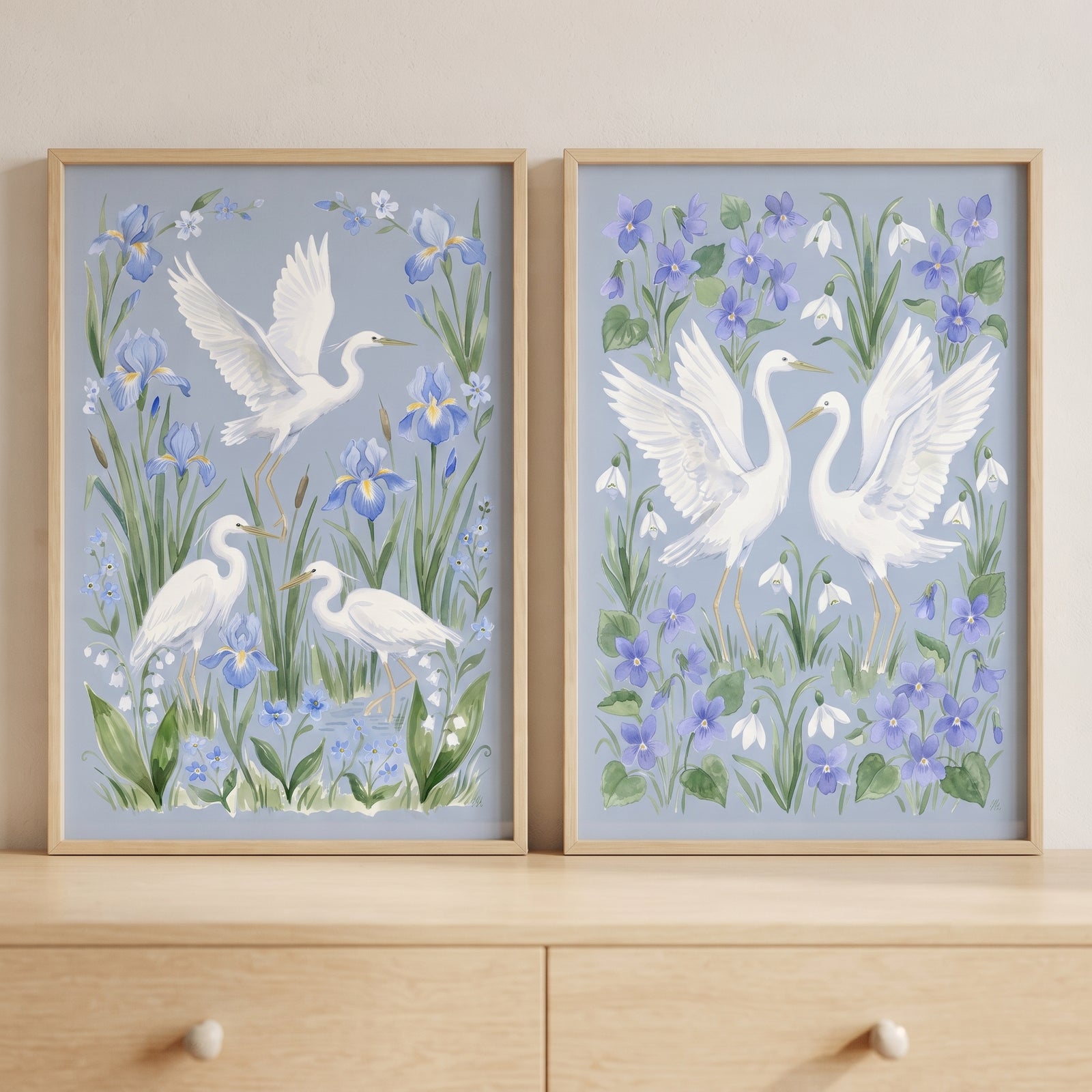 Botanical wetland white egret bird wall art set of 2 with blue irises and delicate flowers in light wood frames.