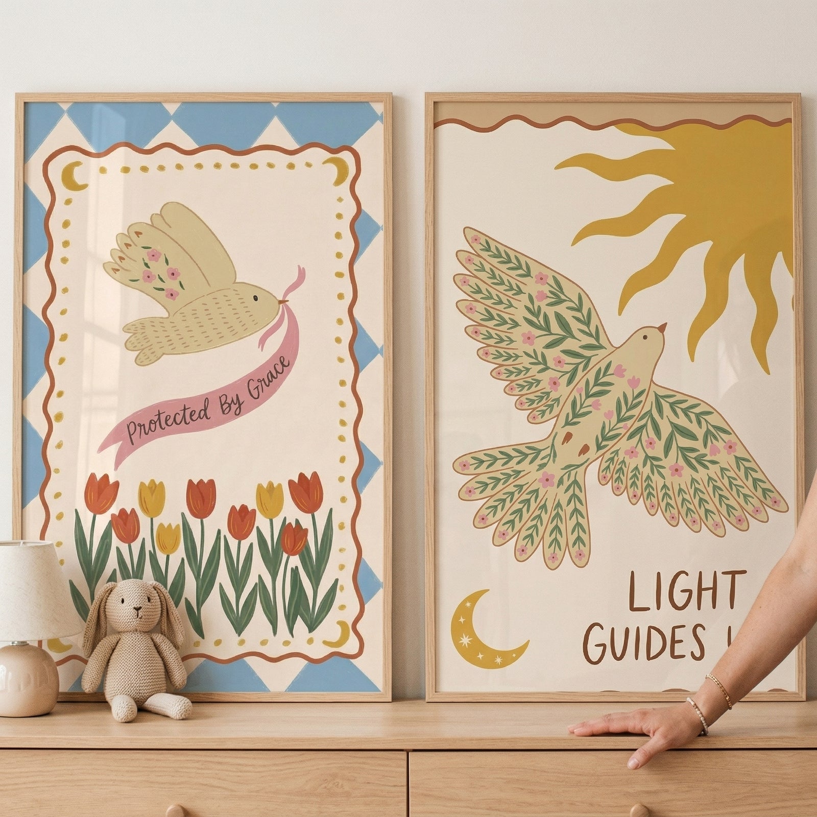 Botanical wing flying bird artwork set of 2 features two framed prints of birds with floral wings, a sun, and tulips.