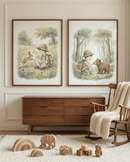 Two framed watercolor-style illustrations hang on a neutral wall above a wooden dresser. The left art shows a boy in explorer clothes sitting in a meadow with a rabbit. The right art depicts him in a forest, kneeling to feed a small bear. To the right, a wooden rocking chair is draped with a cream knit blanket. On a white textured rug are various wooden toys, including a rainbow stacker, a toy elephant, a camera, and alphabet blocks.
