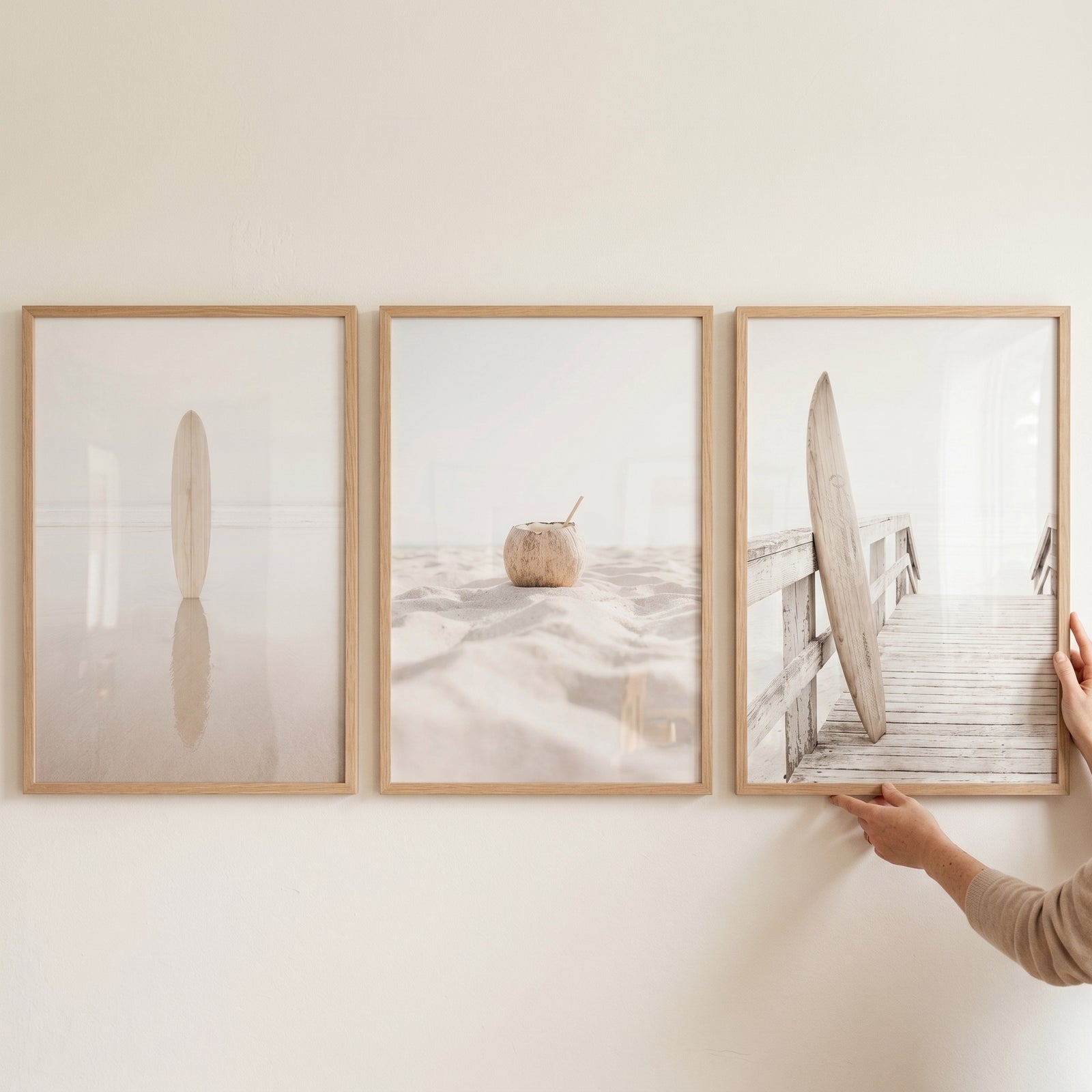 Bright neutral landscape beach wall art set of 3 featuring a surfboard, coconut, and wooden pier in soft tones.