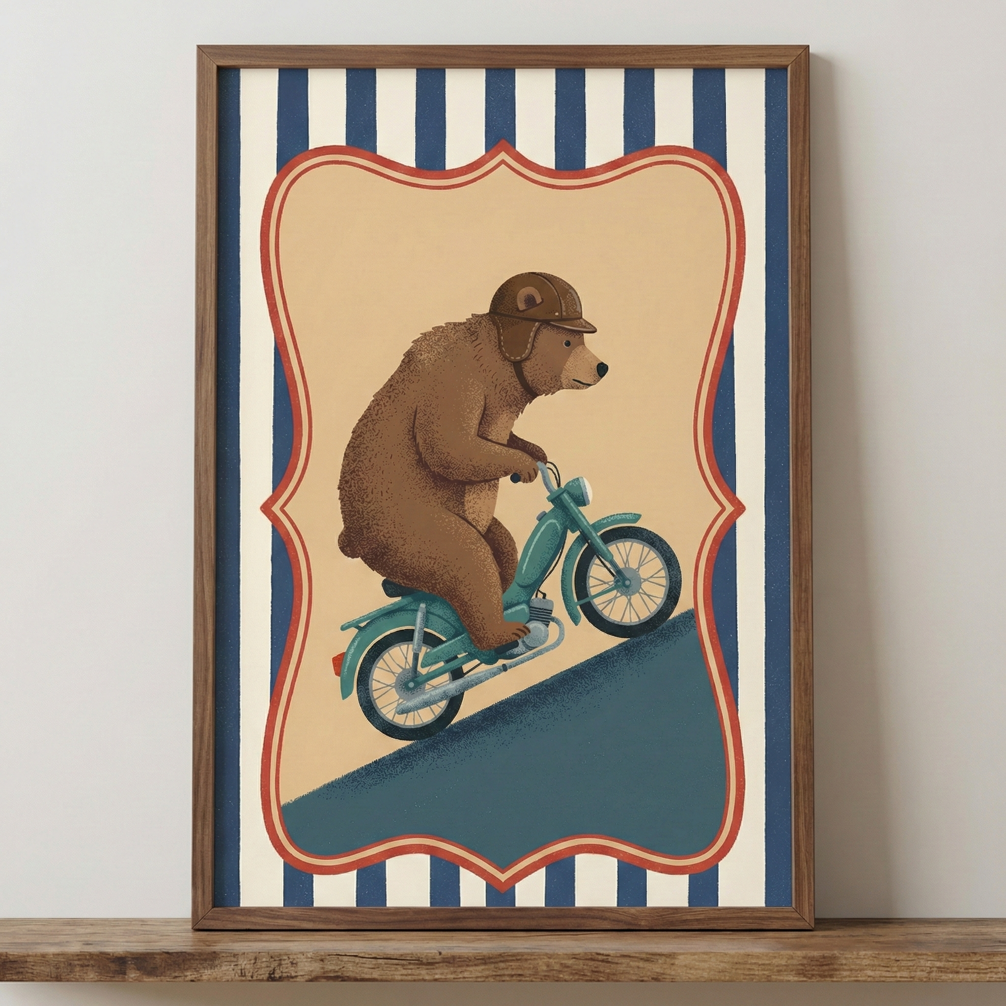 A framed illustration featuring a brown bear wearing a leather-style helmet and riding a small teal motorcycle up a steep, dark blue slope. The bear sits upright with its paws on the handlebars. The central image is contained within a decorative, scalloped red and cream border, set against a background of vertical navy blue and off-white stripes. The artwork is enclosed in a natural wood frame and sits on a wooden shelf.
