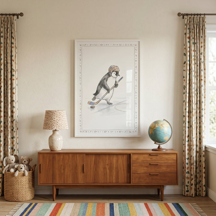 Brown helmet hockey penguin wall art above a wood sideboard with a lamp, globe, and plush toys in a basket.