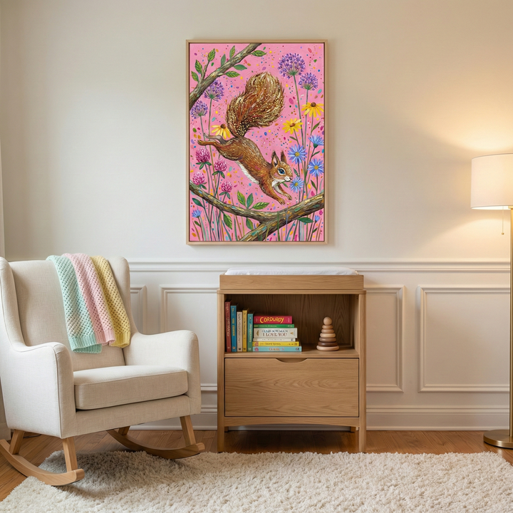 A serene and well-lit nursery or child's room features neutral-toned walls with decorative molding. Centered on the wall is a framed piece of artwork depicting a lively brown squirrel leaping between tree branches. The artwork's background is a vibrant pink, filled with stylized flowers in shades of purple, yellow, and blue.
