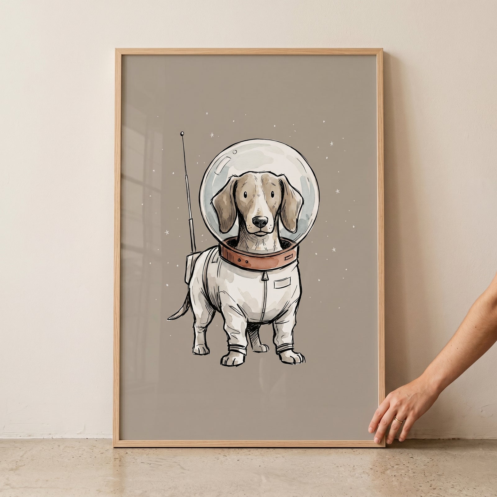 Bubble helmet astronaut dachshund wall art featuring a brown and white dog in a space suit on a tan background.