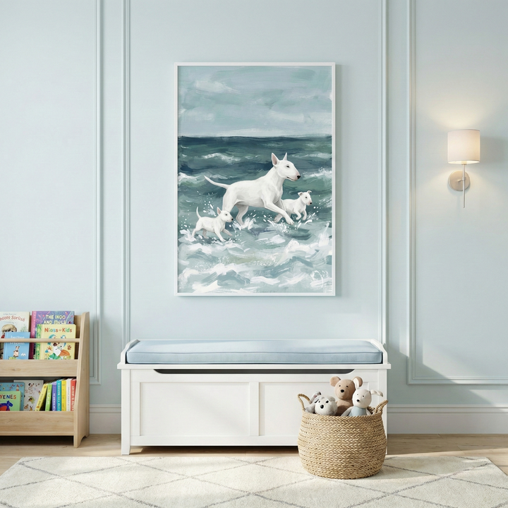 A light blue room features a framed artwork of a white dog and two puppies running through ocean waves. Below sits a white storage bench with a blue cushion. To the left, a wooden bookshelf holds colorful books, and to the right, a woven basket contains soft plush animals. The walls have decorative molding and a modern wall lamp. A cream-colored rug covers the light wood floor, creating a bright and airy nursery setting.