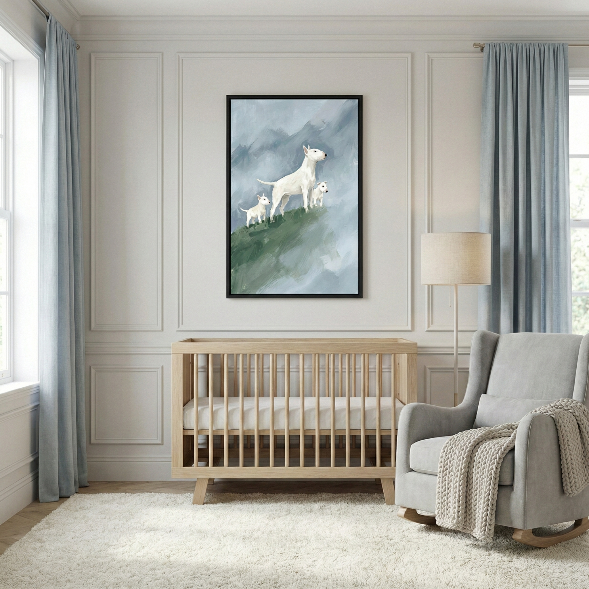 A serene nursery room features a light-colored wooden crib centered against a wall with decorative panel molding. Above the crib hangs a large framed piece of art depicting a majestic white dog and two smaller pups standing on a green hillside under a soft, misty sky. To the right of the crib, a comfortable grey rocking chair is draped with a chunky knit white blanket, positioned next to a tall floor lamp with a simple beige shade. 