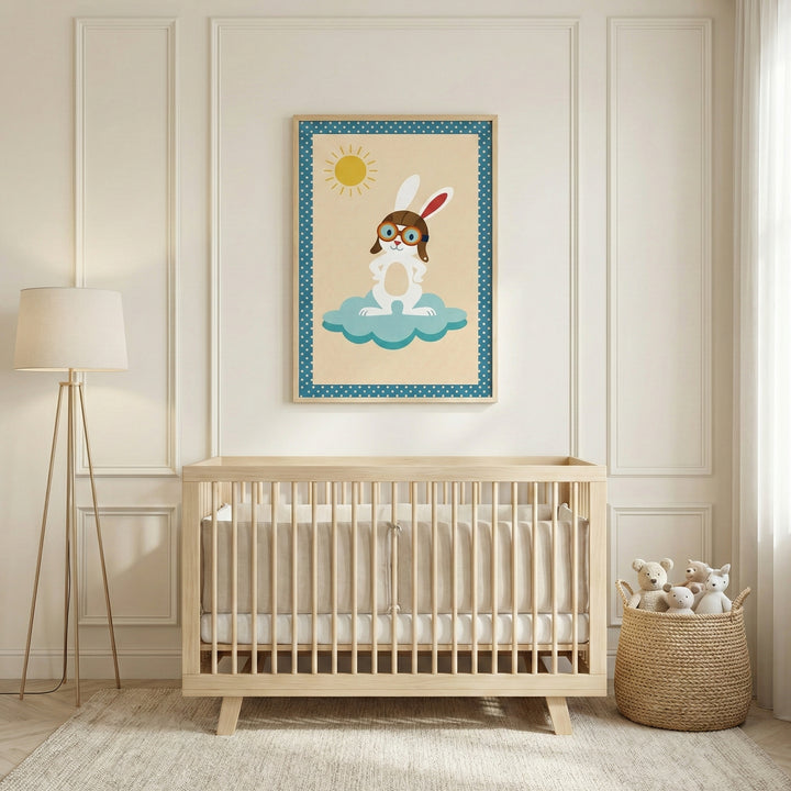 A modern, neutrally-toned nursery featuring a light-wood crib against a paneled white wall. Above the crib hangs a framed illustration of a cartoon rabbit dressed in aviator gear, standing on a blue cloud under a yellow sun. A tripod floor lamp with a white shade stands to the left, and a woven basket filled with small plush teddy bears sits on the floor to the right. The scene is set on a light-colored rug with soft natural light coming from a window.
