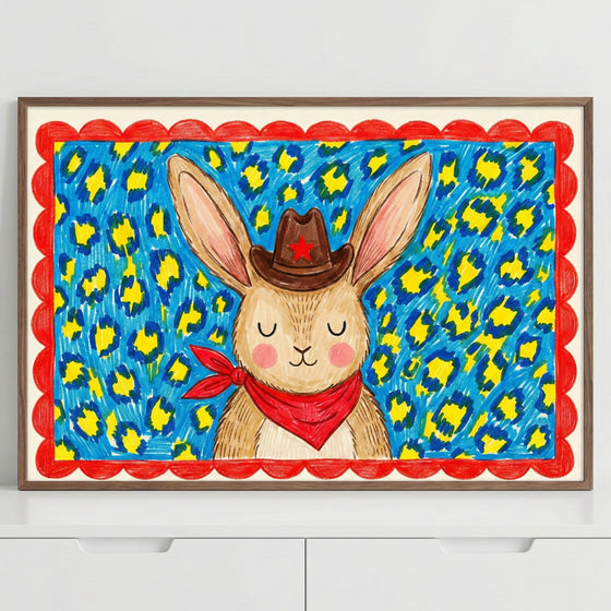 Framed bunny wall art featuring a smiling rabbit with oversized ears in a western outfit, surrounded by a vivid animal print background. The vibrant colors and bold patterns give this wall art a fun and energetic personality.